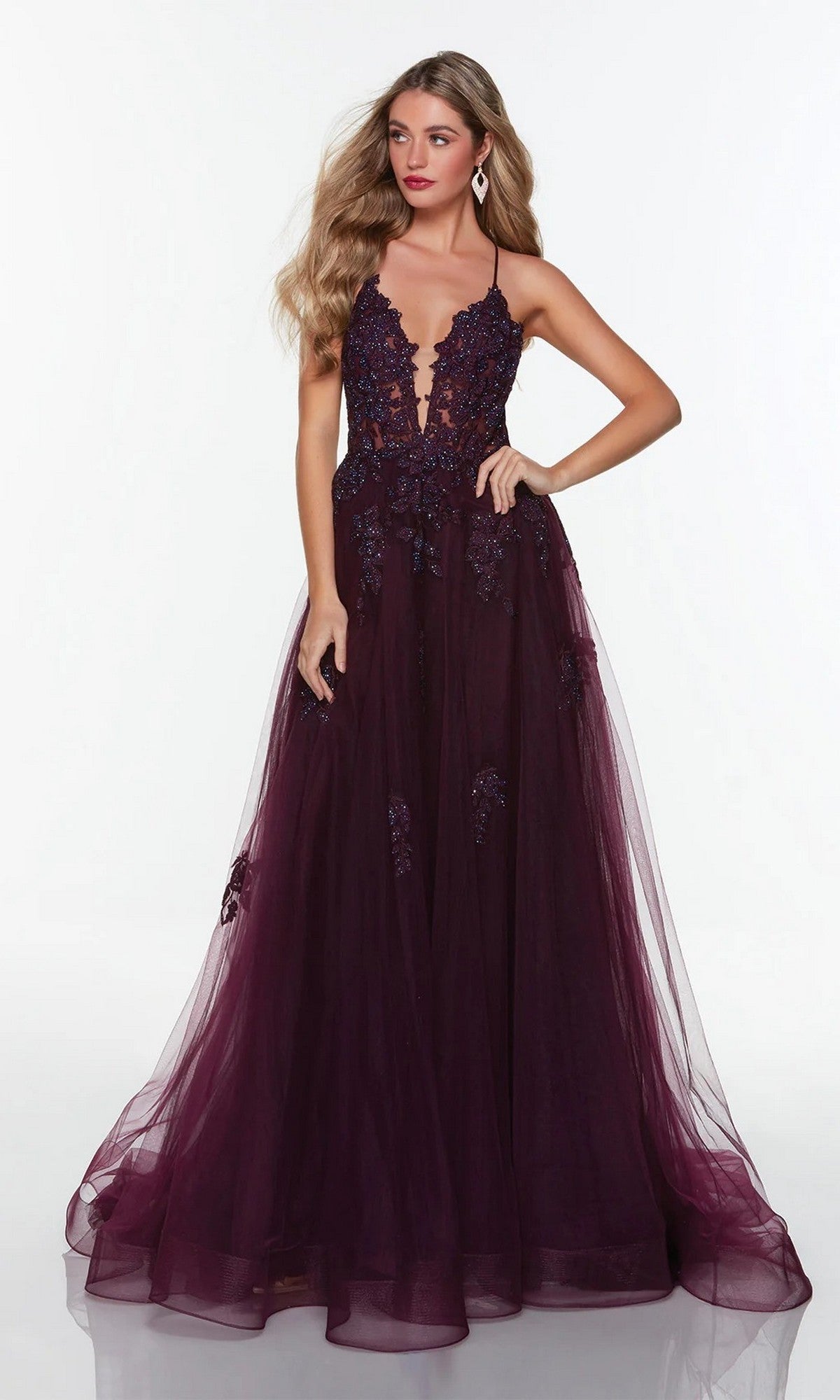 A woman wearing the Alyce 61263 long formal dress—a deep purple ball gown with a plunging neckline, lace appliques, and a full tulle skirt—stands against a plain white background.